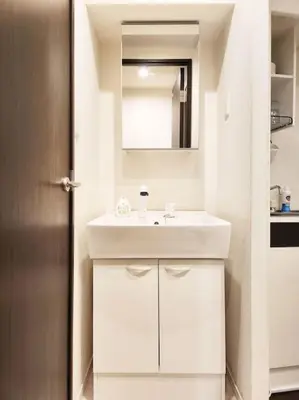 a white bathroom with a sink and a mirror at \u30a2\u30f3\u30c9\u30b9\u30c6\u30a4\u3059\u3082\u3046\u30db\u30c6\u30eb403 in Tokyo