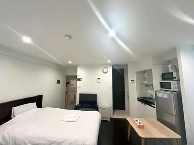 a bedroom with a bed and a table in it at \u30a2\u30f3\u30c9\u30b9\u30c6\u30a4\u3059\u3082\u3046\u30db\u30c6\u30eb403 in Tokyo