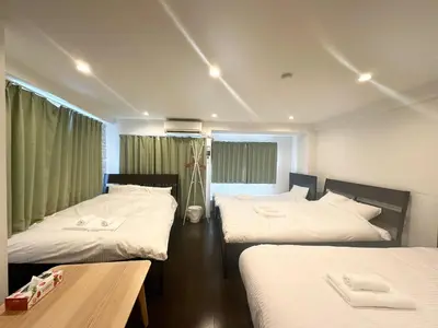 a hotel room with two beds and a table at \u30a2\u30f3\u30c9\u30b9\u30c6\u30a4\u3059\u3082\u3046\u30db\u30c6\u30eb403 in Tokyo