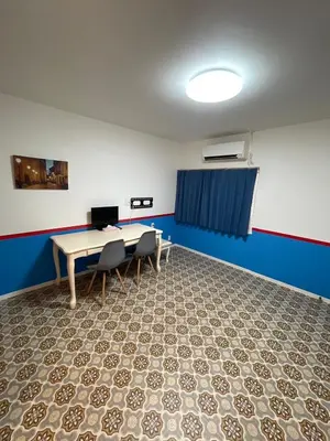 a room with a table and chairs and a blue wall at \u30a2\u30f3\u30c9\u30b9\u30c6\u30a4\u30ce\u30dc\u30c3\u30c1\u30db\u30c6\u30eb101 in Tokyo