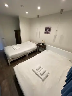 a bedroom with two beds with towels on them at \u30a2\u30f3\u30c9\u30b9\u30c6\u30a4\u30ce\u30dc\u30c3\u30c1\u30db\u30c6\u30eb101 in Tokyo