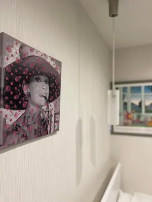 a painting of a woman with an umbrella on a wall at \u30a2\u30f3\u30c9\u30b9\u30c6\u30a4\u30ce\u30dc\u30c3\u30c1\u30db\u30c6\u30eb101 in Tokyo