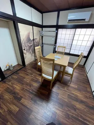 a dining room with a table and chairs at \u30a2\u30f3\u30c9\u30b9\u30c6\u30a4\u30ce\u30dc\u30c3\u30c1\u30db\u30c6\u30eb201 in Tokyo