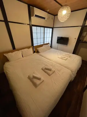 a bedroom with a large bed with two towels on it at \u30a2\u30f3\u30c9\u30b9\u30c6\u30a4\u30ce\u30dc\u30c3\u30c1\u30db\u30c6\u30eb201 in Tokyo