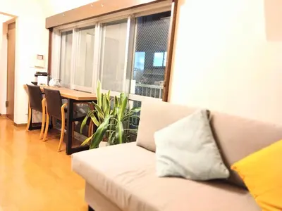 a living room with a couch and a dining table at Casa Tokyo -Arakicho- in Tokyo