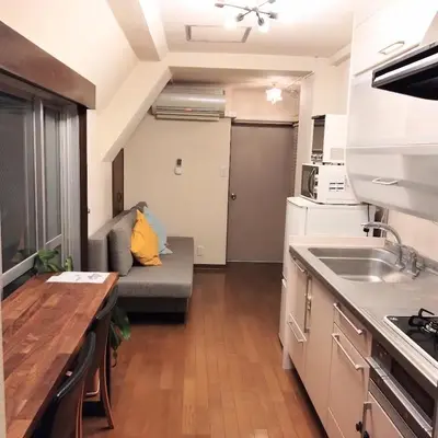 a living room with a couch and a kitchen at Casa Tokyo -Arakicho- in Tokyo
