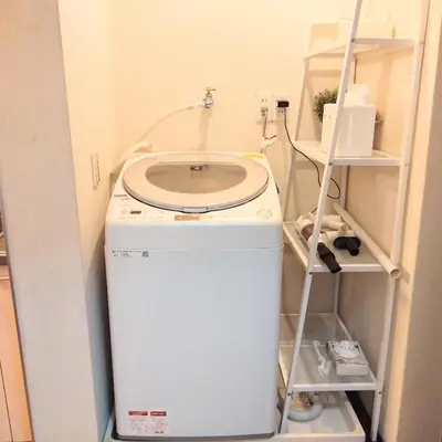 a washing machine in a room with a shelf at Casa Tokyo -Arakicho- in Tokyo