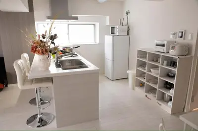 a kitchen with a sink and a white refrigerator at \u862d\u5712 Village Gotanda \u5c4b\u4e0a\u30ac\u30fc\u30c7\u30f3\u30c6\u30e9\u30b9\u4ed8\u304d in Tokyo