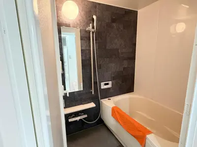a bathroom with a bath tub and a mirror at \u862d\u5712 Village Gotanda \u5c4b\u4e0a\u30ac\u30fc\u30c7\u30f3\u30c6\u30e9\u30b9\u4ed8\u304d in Tokyo