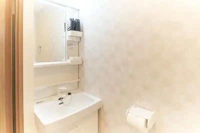 a bathroom with a toilet and a sink and a mirror at Sky Up Oshiage by Tranova in Tokyo