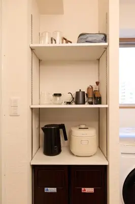 a kitchen shelf with pots and pans and a toaster at Home Story in Tokyo Ueno&Uguisudani-小島ビル&東京屋語 in Tokyo