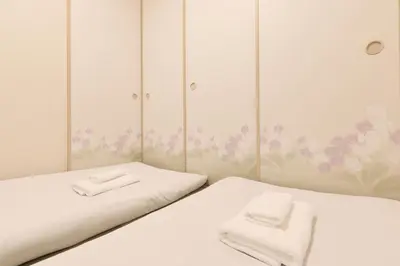 two beds in a room with flowers on the wall at Home Story in Tokyo Ueno&Uguisudani-小島ビル&東京屋語 in Tokyo