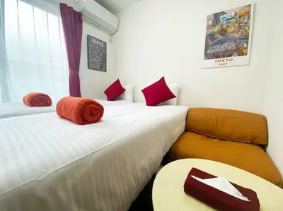 a room with two beds and a table in it at Skytree & Asakusa in front! Newly built 202 in Tokyo