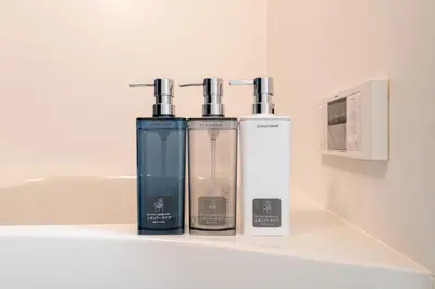 three bottles ofodorizers sitting on a shelf in a bathroom at Provence Hotel in Tokyo