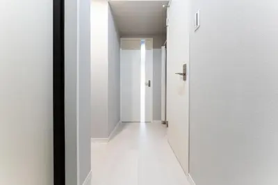 a hallway with white walls and a white door at Provence Hotel in Tokyo