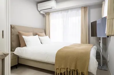 a bedroom with a white bed with a window at Provence Hotel in Tokyo