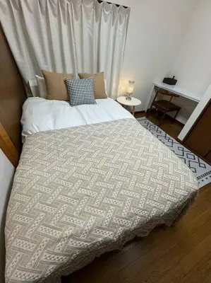 a bedroom with a bed with a white comforter at Golden House in Tokyo