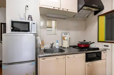a small kitchen with a refrigerator and a sink at Golden House in Tokyo