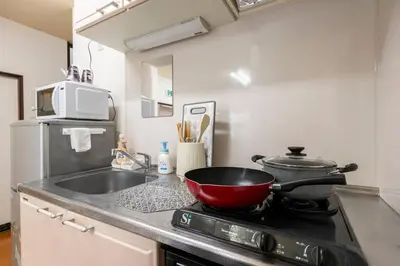 a kitchen with a red bowl on a stove at Golden House in Tokyo