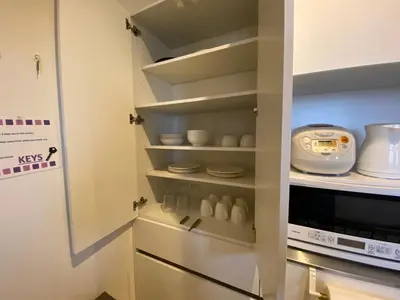 a kitchen with a microwave and some dishes at PRISM COURT HIRAI Room 801 in Tokyo