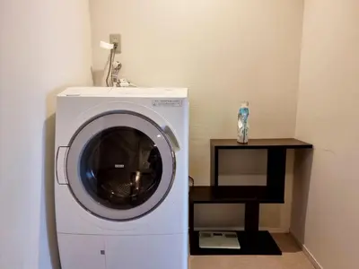 a washing machine in a room with a table at PRISM COURT HIRAI Room 801 in Tokyo