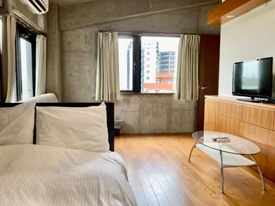 a bedroom with a bed and a tv and a table at PRISM COURT HIRAI Room 801 in Tokyo