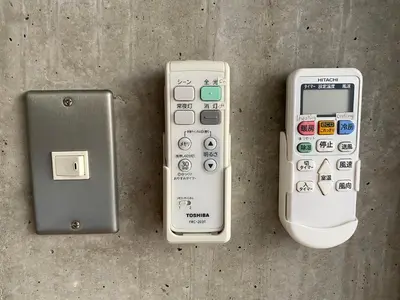 three remote controls sitting on top of a table at PRISM COURT HIRAI Room 801 in Tokyo