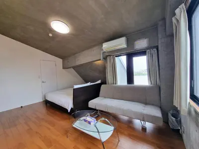 a living room with a couch and a table at PRISM COURT HIRAI Room 801 in Tokyo