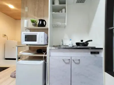 a small kitchen with a microwave and a refrigerator at D22\u65b0\u5bbf\u6700\u4e2d\u5fc3 \u4e24\u5ba4 \u65b0\u5927\u4e45\u4fdd\u7ad95\u5206-2 rooms Shinjuku center 5 mins to ST Max 4P \u65b0\u5bbf \u6d89\u8c37 \u8868\u53c2\u9053 \u6c60\u888b \u4e0a\u91ce \u4ee3\u4ee3\u6728 \u94f6\u5ea7 \u539f\u5bbf in Tokyo