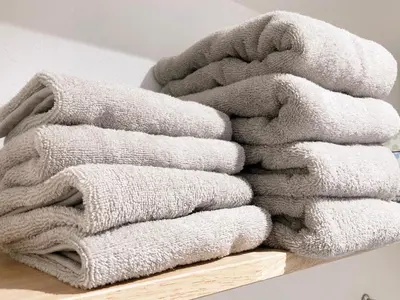 a pile of towels sitting on a wooden shelf at Akariya Asakusa in Tokyo