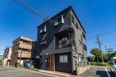 a black building on the side of a street at 84-1, Shiomi 101, Entire room for rent, \u6f6e\u898bB101 in Tokyo