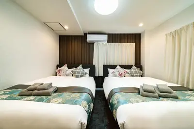 a hotel room with two beds and a television at 84-1, Shiomi 101, Entire room for rent, \u6f6e\u898bB101 in Tokyo