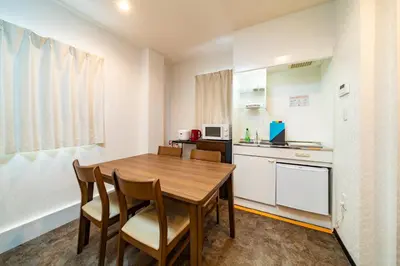 a kitchen and dining room with a wooden table and chairs at 84-1, Shiomi 101, Entire room for rent, \u6f6e\u898bB101 in Tokyo