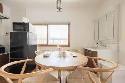 a kitchen with a table and chairs and a refrigerator at Fit-Inn\u7530\u539f\u753a in Tokyo