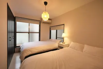 a bedroom with two beds and a window at Urban House Nakano in Tokyo