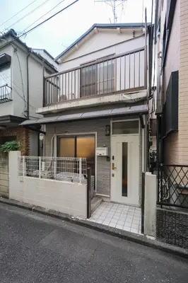 a house with a balcony on the side of a street at Urban House Nakano in Tokyo