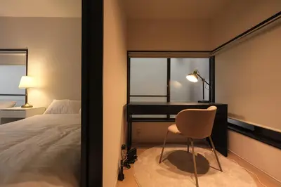 a bedroom with a desk and a chair next to a bed at Urban House Nakano in Tokyo