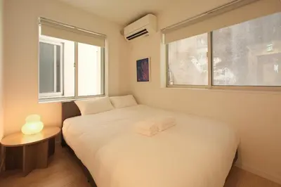 a bedroom with a white bed and a window at Urban House Hatagaya in Tokyo