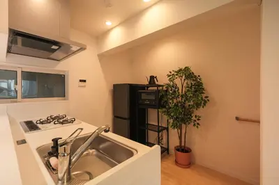 a kitchen with a sink and a stove at Urban House Hatagaya in Tokyo