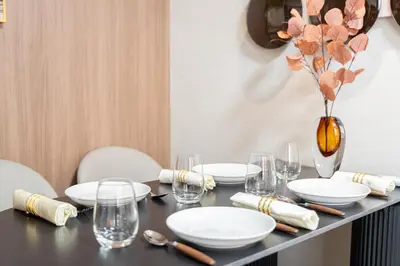 a table with plates and glasses and a vase with flowers at Z7\u5168\u65b0\u88c5\u4fee\u5957\u623f3\u5ba42\u5385 \u65b0\u5bbf2\u7ad94\u5206\u949f,Max 8p-spacious,3rooms Near Shinjuku in Tokyo