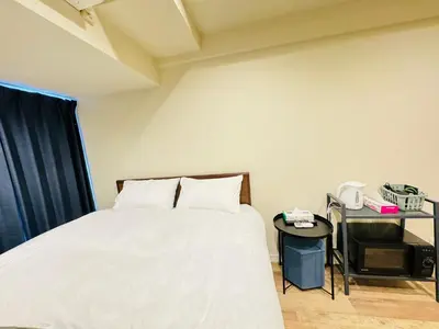 a bedroom with a white bed and a table at kabukicho 910 SJ0275 in Tokyo