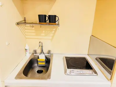 a small kitchen with a sink and two cups on a shelf at kabukicho 910 SJ0275 in Tokyo