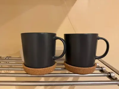 two black coffee cups sitting on top of a stove at kabukicho 910 SJ0275 in Tokyo
