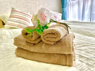 a pile of towels and a flower on a bed at J5-\u6771\u4eac\u4e2d\u5fc3 \u99d2\u8fbc\u99c54\u5206\u8fd1\u5546\u4e1a\u8857 4mins to ST Max 4P \u76f4\u8fbe\u65b0\u5bbf \u6e0b\u8c37 \u8868\u53c2\u9053 \u6c60\u888b \u4e0a\u91ce \u4ee3\u4ee3\u6728 \u9280\u5ea7 \u539f\u5bbf in Tokyo