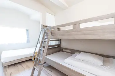 a bunk bed room with two bunk beds and a ladder at \u30d9\u30eb\u9418 in Tokyo