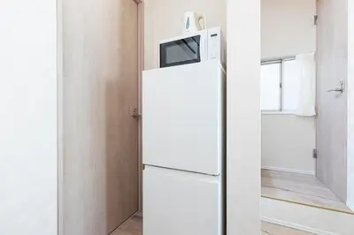 a refrigerator with a microwave on top of it at \u30d9\u30eb\u9418 in Tokyo