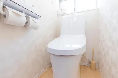 a bathroom with a white toilet with a window at \u30d9\u30eb\u9418 in Tokyo