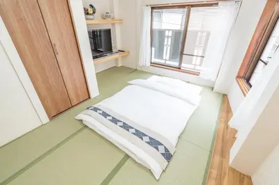 a small room with a bed and a window at \u532f\u5bb6\u672c\u753a\u30d3\u30eb in Tokyo