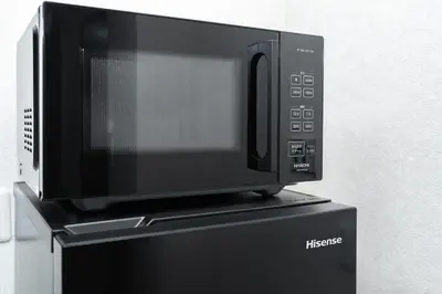 a microwave oven sitting on top of a refrigerator at \u532f\u5bb6\u672c\u753a\u30d3\u30eb in Tokyo