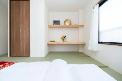 a bedroom with a white bed and a window at \u532f\u5bb6\u672c\u753a\u30d3\u30eb in Tokyo